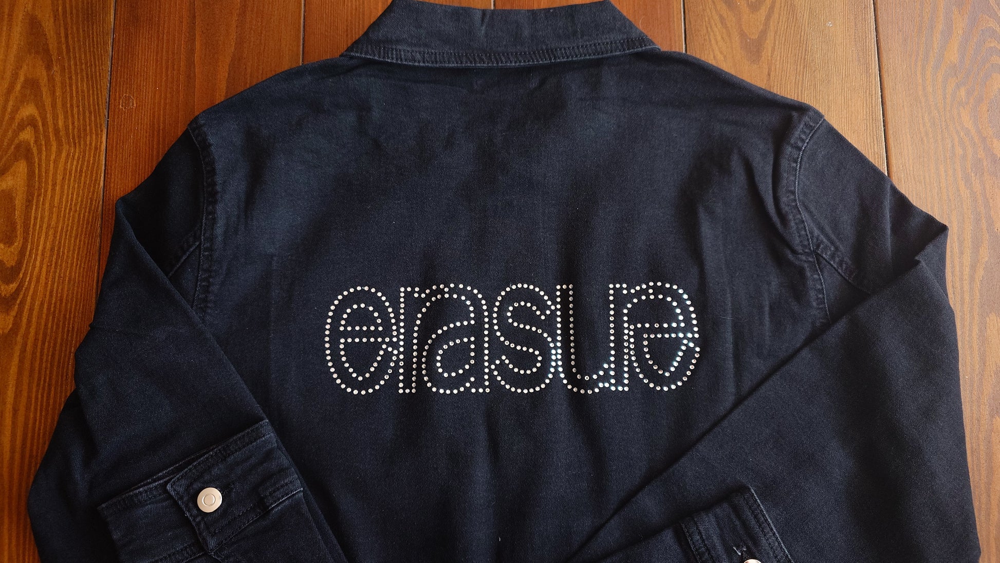 Soft denim jacket with silver rhinestones spelling out ERASURE on the back