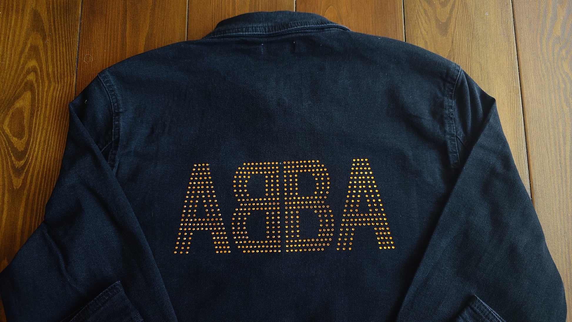 soft black denim jacket with gold sparkling rhinetsones spelling out ABBA on the back