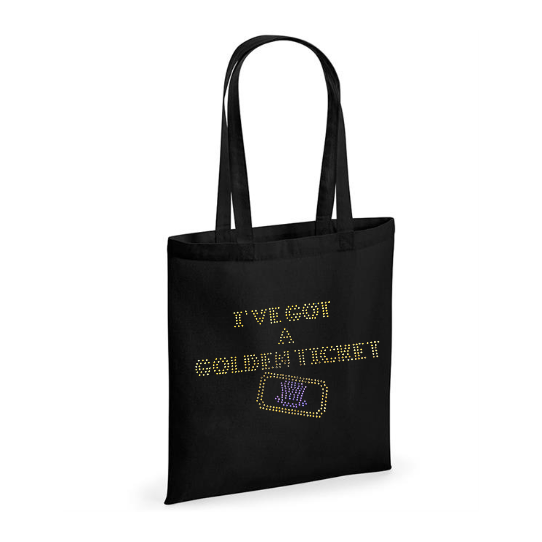 Black cotton tote bag with long handles, on the front, I've got a golden ticket lettering, set just below this is the outline of a golden ticket with purple wonka inspired hat set in the middle of the ticket.
