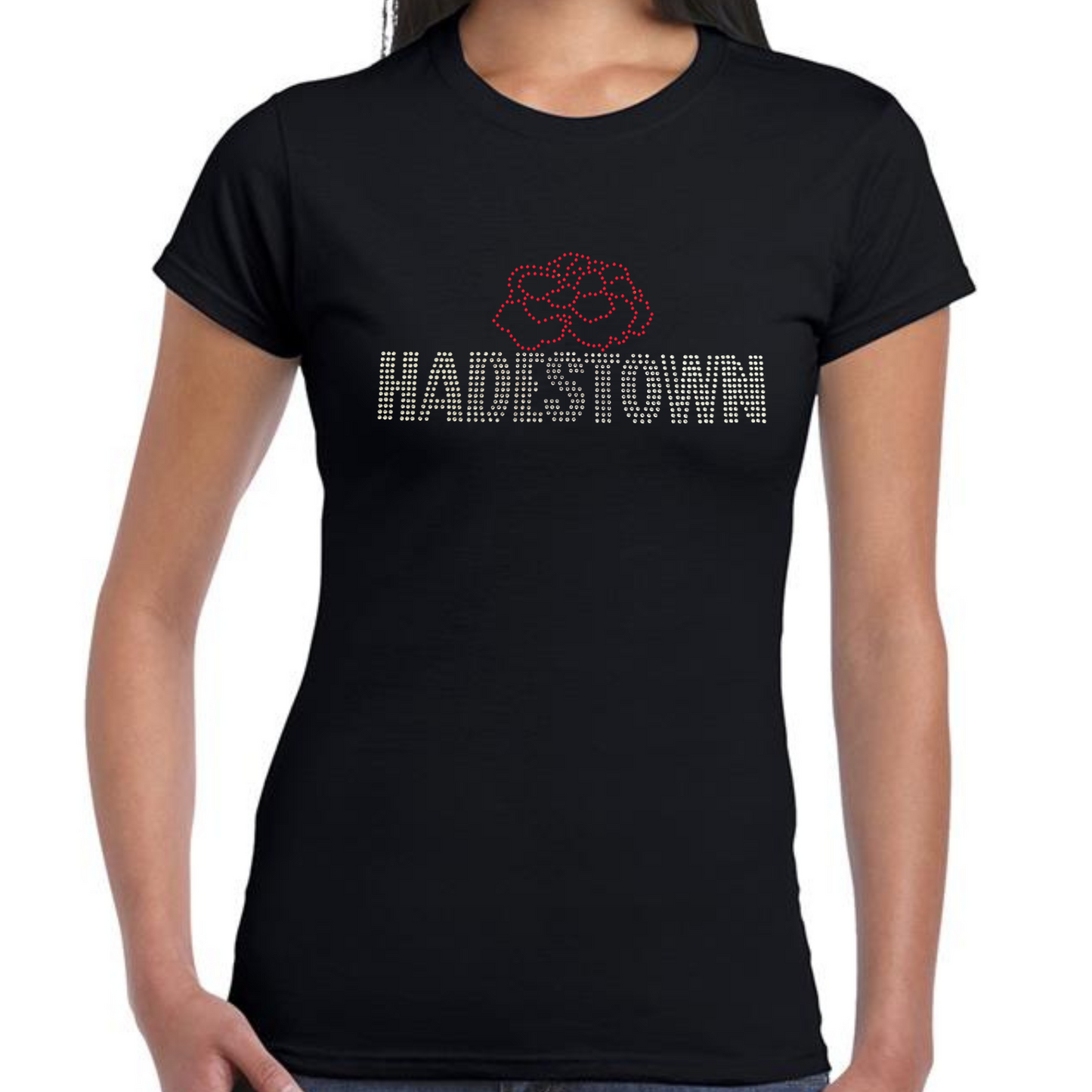 Black short sleeve ladies t shirt, on the front there is silver HADESTOWN lettering in capitals, there is then a red carnation flower design resting on the middle of the lettering
The design is made up of sparkling rhinestones that catch the light