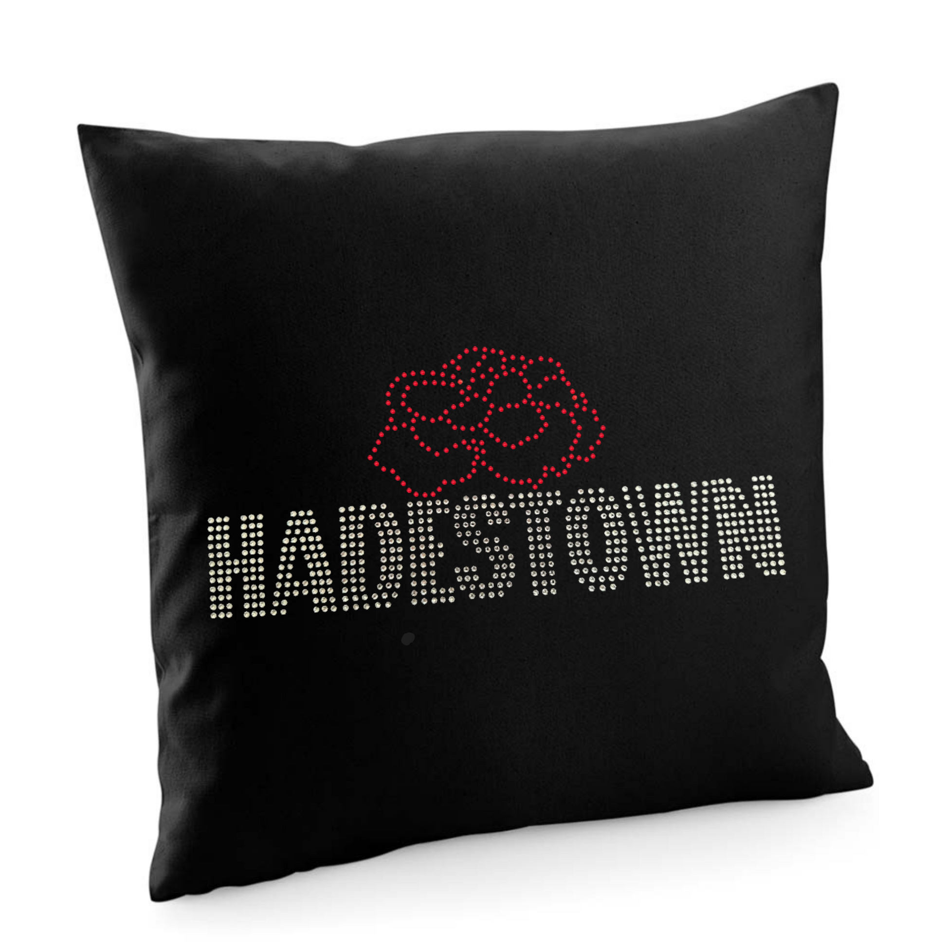 HADESTOWN BLACK COTTON CUSHION COVER WITH SILVER HADESTOWN WRITING AND THE OUTLINE OF A CARNATION SET ABOVE THE MIDDLE OF THE LETTERING.
THE DESIGN IS MADE UP OF HOT FIX RHINESTONES THAT HEAT PRESSED AND CATCH THE LIGHT BEAUTIFULLY