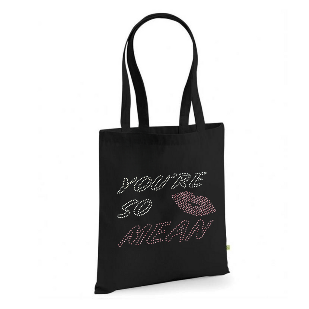 Mean girls, Black cotton heavy tote bag with long handles, on the front of the t shirt, is silver and pink sparkly writing spelling out 'You're so mean" the last word mean is in pink, set in the middle of the lettering is a set of pink lips.