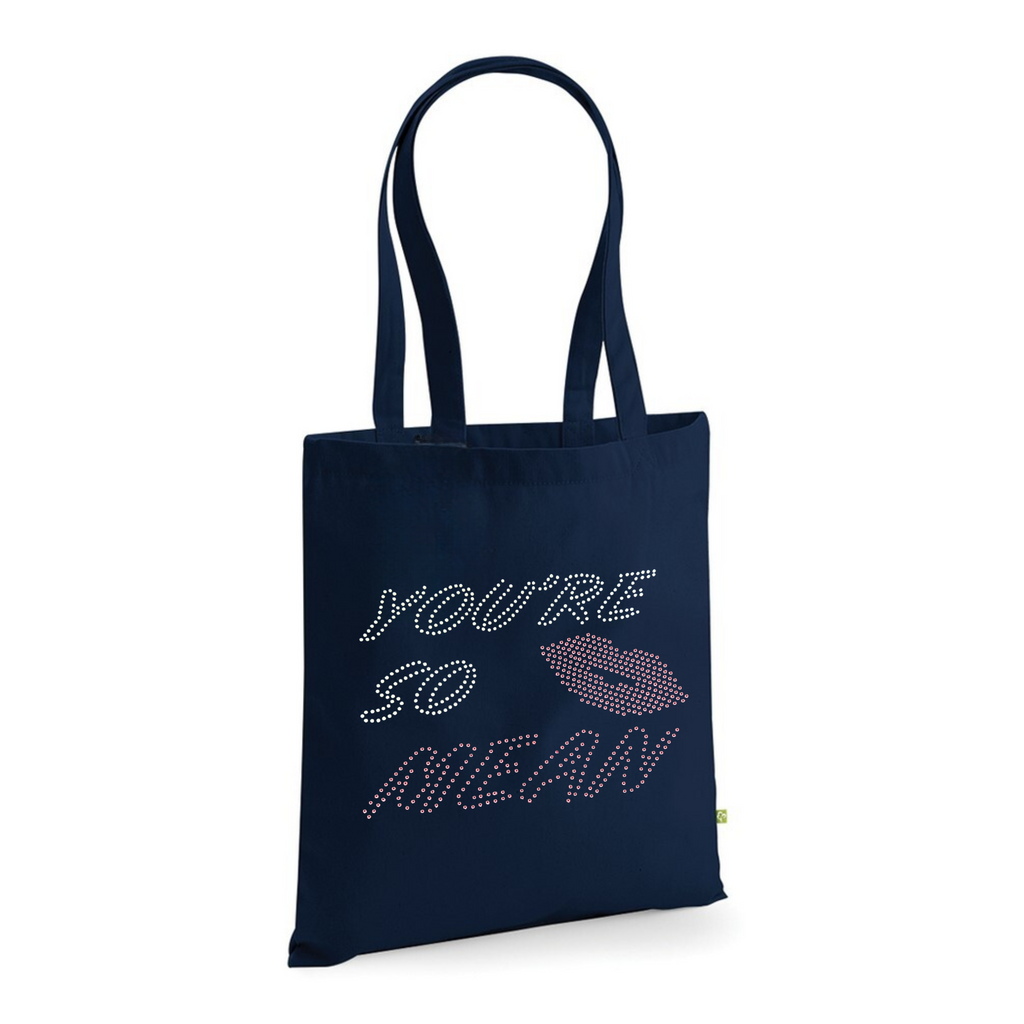 Mean girls, navy cotton heavy tote bag with long handles, on the front of the t shirt, is silver and pink sparkly writing spelling out 'You're so mean" the last word mean is in pink, set in the middle of the lettering is a set of pink lips.