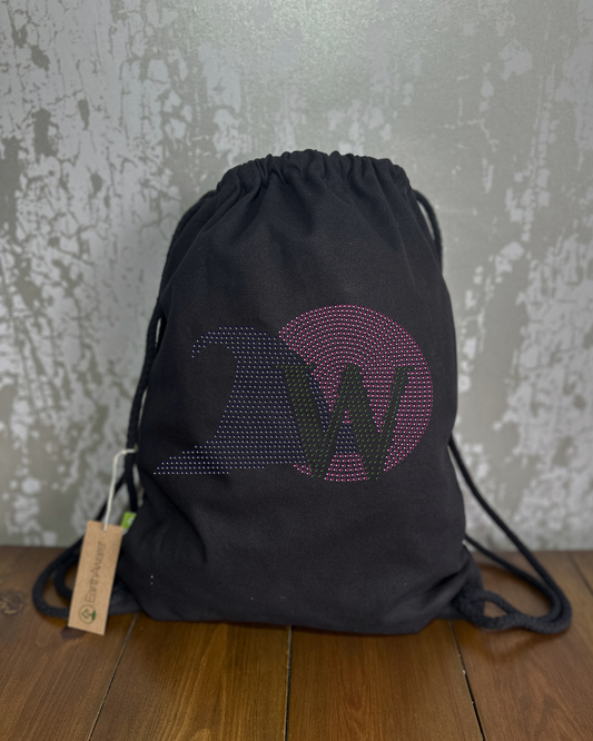 BLACK COTTON DRAWSTRING BAG MADE WITH THICK DURABLE MATERIAL. THE BAG HAS A CORD DRAWSTRING THAT ACT AS SHOULDER STRAPS. ON THE FRONT OF THE BAG IS A WICKED INSPIRED DESIGN. THERE IS LARGE PINK BUBBLE TO REPRESENT GLINDA'S BUBBLE, WITH A BLACK HAT SET INTO IT AND GREEN W TO REPRESENT ELPHABA AND THE GREEN OF OZ. THE DESIGN IS MADE UP OF HOT FIX RHINESTONES THAT HEAT PRESSED AND CATCH THE LIGHT BEAUTIFULLY