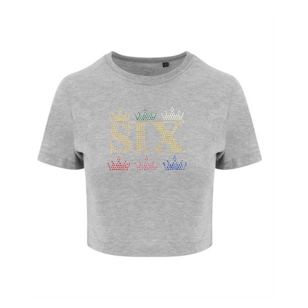 GREY CROP T SHIRT, ON THE FRONT IS GOLD SIX LETTERING ABOVE AND BELOW THE LETTERING ARE THREE CROWNS A COLOUR FOR EACH QUEEN. SO A GOLD, GREEN AND SILVER CROWN ABOVE AND A RED, PINK AND BLUE CROWN UNDERNEATH. THE DESIGN IS MADE UP OF HOT FIX RHINESTONES THAT HEAT PRESSED AND CATCH THE LIGHT BEAUTIFULLY